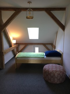 Schlafzimmer mit Holzbalken im Obergeschoss